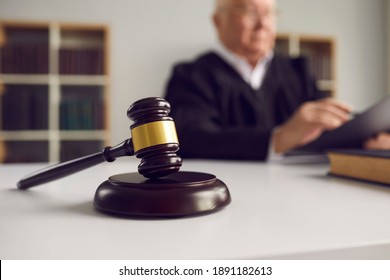 Close-up Of Dark Brown Wooden Gavel Placed On Sound Block On Judge's Table In Courtroom During Court Hearing. Concept Of Law And Justice, Just Verdict, Fair Judgement And Final Sentence