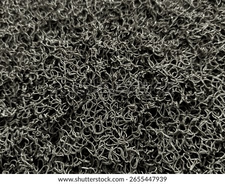 Close-up of a dark grey, tangled loop-pile texture, resembling a doormat or industrial mat. Perfect for abstract backgrounds or material design. #TextureBackground #DoormatTexture #AbstractPattern #In