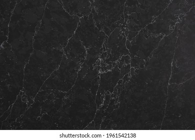 Closeup Of A Dark Marble Looking Quartz Slab That Contains A Two-toned Charcoal Grey Background With Soft Light Grey Subtle Veins