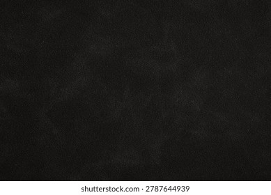 A close-up of a dark, textured surface with subtle reflective particles.