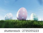 Close-up of decorative Easter eggs with pastel polka dots and floral patterns in green grass. Egg with clear blue sky background, perfect for spring holiday designs.