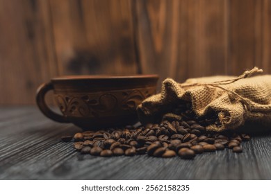 Close-up of a decorative rustic cup and a burlap sack spilling roasted coffee beans on a wooden surface, with a warm wooden background. - Powered by Shutterstock