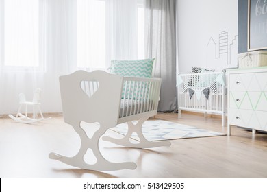Close-up of a decorative white cradle in a very bright baby room - Powered by Shutterstock