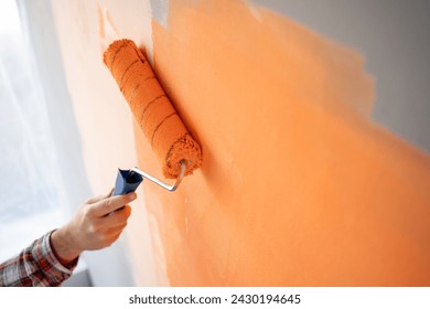 Close-up of decorator's hand painting wall with roller. Copy space - Powered by Shutterstock