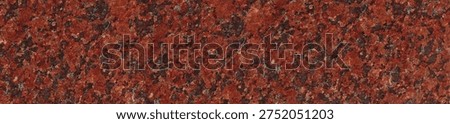 A close-up of deep red granite featuring dark brown and black crystalline grains in a dense natural stone pattern.