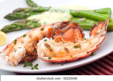 Closeup of delicious grilled lobster tails served with asparagus and bearnaise sauce