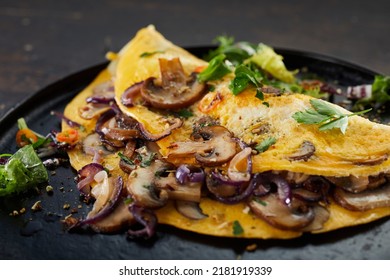 Closeup of delicious omelet with mushrooms and herbs served on table for lunch