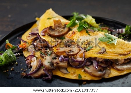 Closeup of delicious omelet with mushrooms and herbs served on table for lunch Stockfoto © 