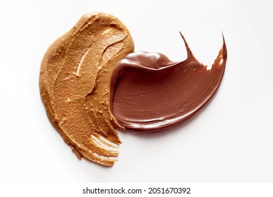 A closeup of delicious peanut butter and chocolate paste spread on white background - Shutterstock ID 2051670392