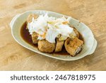 Close-up of delicious stinky tofu on the table. It is a common street snack in night markets or roadside stalls in Taiwan and is very popular among tourists.