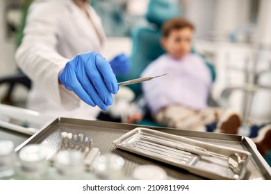 Close-up Of Dentist Using Dental Scraper Tool While Checking Teeth Of A Child At Dentist's Office.