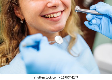 Close-up of the dentist's hands with medical devices. Large detail - dentist's mirror, curling and probe. Resolving dental problems effectively with confident, professional gestures. Smiling widely. - Powered by Shutterstock