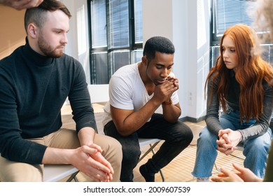 Close-up of depressed African American young man sharing problem sitting in circle on group therapy session. Concept of group consulting of mental health problem with professional psychologist. - Shutterstock ID 2009607539
