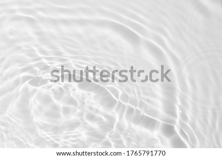 Closeup of desaturated transparent clear calm water surface texture with splashes and bubbles. Trendy abstract nature background. 