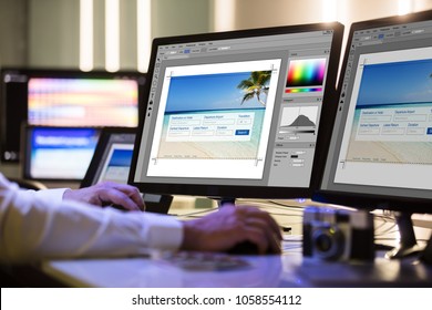 Close-up Of A Designer's Hand Working On Multiple Computer Screen At Workplace