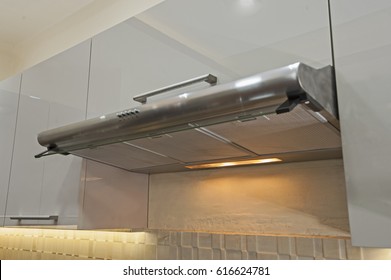 Closeup detail of buttons on metal cooker hood extractor fan with spotlight in luxury kitchen