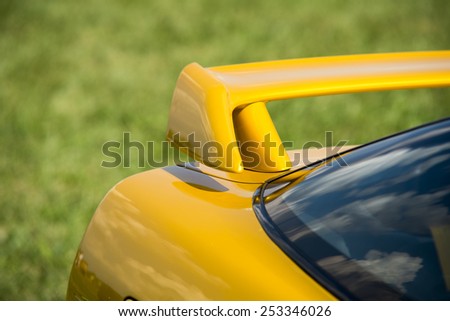 Closeup detail of a custom racing spoiler on the rear of a sports car