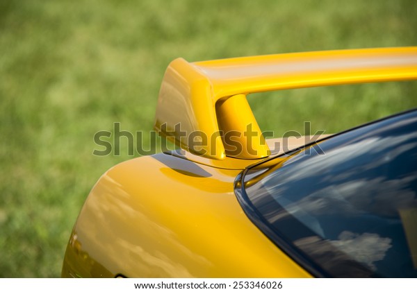 Closeup detail of a custom racing spoiler on the rear\
of a sports car