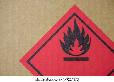 Close-up Detail Of A Fire Hazard Warning Symbol On A Cardboard Cargo Box Containing Chemicals.