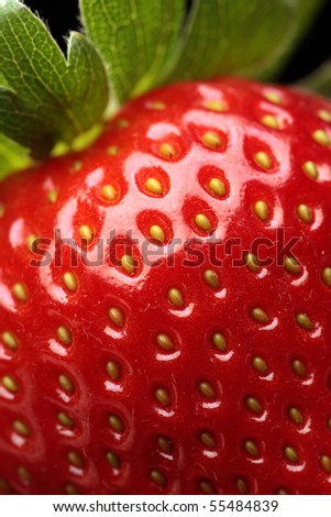 Close-up detail of a fresh red strawberry with leaves