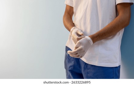 Close-up detail of hands putting on medical gloves, symbolizing protection and care in a clinical or laboratory setting. Ideal for representing a nurse in action.