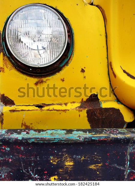Closeup detail of old bumper and headlight on truck\
car scraped paint chips