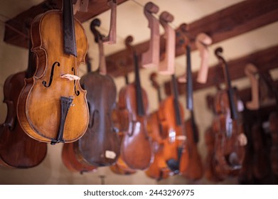 Close-up detail of one of the violins hanging in the master luthier's workshop. Artisan manufacturer of high-end violins - Powered by Shutterstock