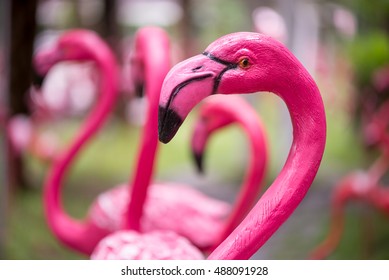 Close-up detail of a pink flamingo sculpture decorating a lawn, with a blurred out background. Home and garden decoration concept. - Powered by Shutterstock