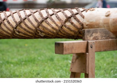 Close-up and detail shot of the trunk of a maypole lying crosswise on supports. The maypole, a German tradition, is groomed and prepared for erection.