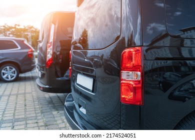 Close-up Detail Tail Light View Of Many Modern Luxury Black Vans Parked In Row At Car Sale Rental Leasing Dealer Against Sunset. Commericial Trasfer Cargo Transportation Company Fleet. Vip Charter