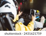 closeup detail of teenager grabbing the steering wheel of the karts in the race on the asphalt track