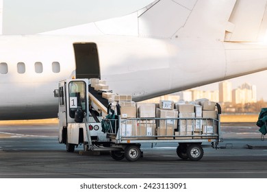 Close-up detail view of cargo cart trolley full with commercial parcels against turboprop cargo plane. Air mail shipping and logistics. Import export operations. Commercial charter flight service - Powered by Shutterstock