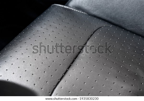 Close-up\
detail view of modern black perforated dotted ventilated luxury car\
seat. Part of dark vehicle interior. Auto detailing and leather\
polish skin cleaning wash and care\
concept