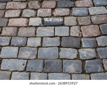 Close-up detail of weathered stone cobblestone pavement showing natural texture and aging patterns