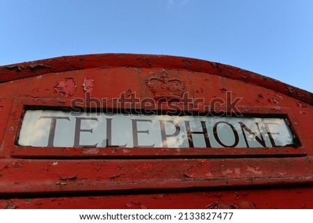 Close-up detail of the word 'Telephone' on a traditional red British phone box 