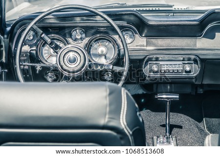 Close-up, detailed photo of the interior, dashboard, steering wheel and speedometer of a classic oldtimer american muscle car.