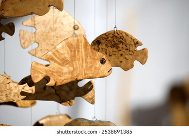 Close-up of detailed wooden fish carvings, expertly crafted and suspended, emphasizing natural textures and artistic design in home decoration. - Powered by Shutterstock