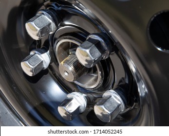 closeup details of chromed automobile wheel lug nuts - Shutterstock ID 1714052245