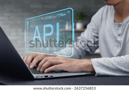 A close-up of a developer's hands typing on a laptop with a digital API interface projected above, highlighting modern programming and technology concepts in a workspace.