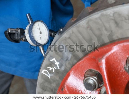 ​A close-up of a dial indicator measuring the runout of a crown gear differential.