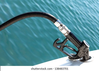 Closeup of Diesel pump nozzle refilling boat tank.