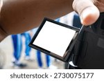 Close-up of a digital camera LCD screen with a white blank space for mockup, held by a photographer