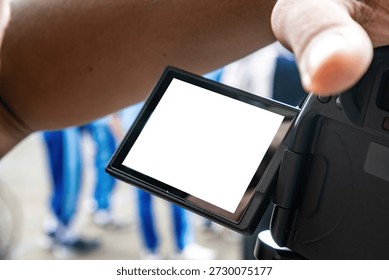Close-up of a digital camera LCD screen with a white blank space for mockup, held by a photographer
