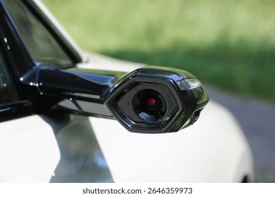 Close-up of a digital side mirror camera on a modern car, showcasing advanced automotive design and futuristic technology.

