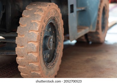 Close-up At Dirty Big Wheel Of Forklift Vehicle, A Cargo Logistic Industrial Equipment Photo. Selective Focus At The Tire Part.