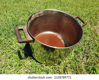 Closeup Of Dirty Cooking Pot Isolated On Green Grass Background. High Angle Shot. 