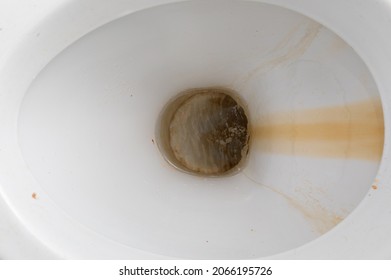 close-up dirty toilet bowl, traces of limescale and rust