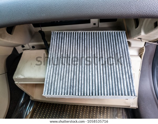 closeup of dirty\
unhealthy ac air cleaning filter of a modern vehicle lots of dust\
and sand in it inside the\
car