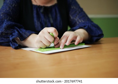 Close-up Of Disability Blind Person Woman Hands Writing Braille Text On Paper By Using Slate And Stylus Tools Making Embossed Printing For Braille Character Encoding. 