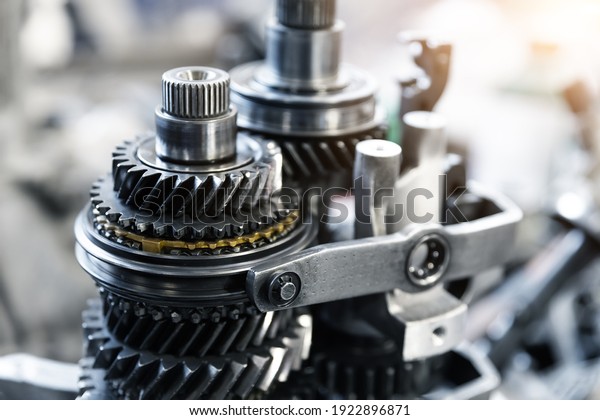 Closeup disassembled car automatic\
transmission gear part on workbench at garage or repair factory\
station for fix service or maintenance. Vehicle part detail.\
Complex industrial mechanism\
background